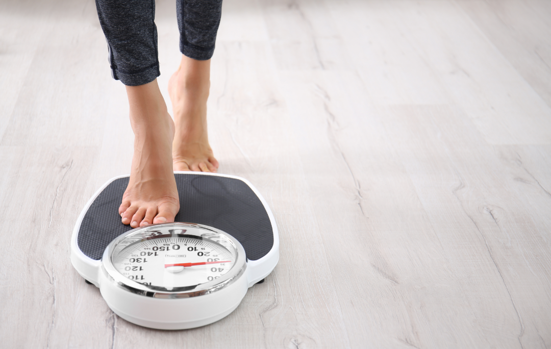 A person stepping on a scale to track progress during a medical weight loss program.