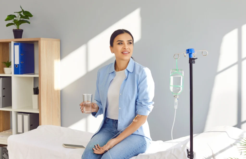 A woman receiving an IV drip for hydration in a medical setting.