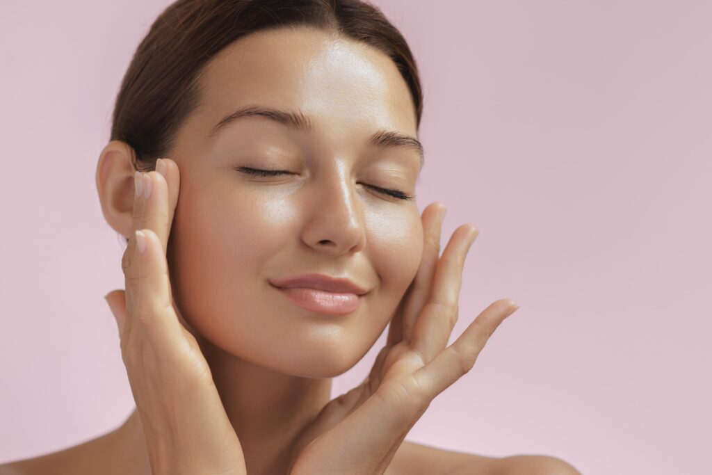 Woman touching her glowing face after facials